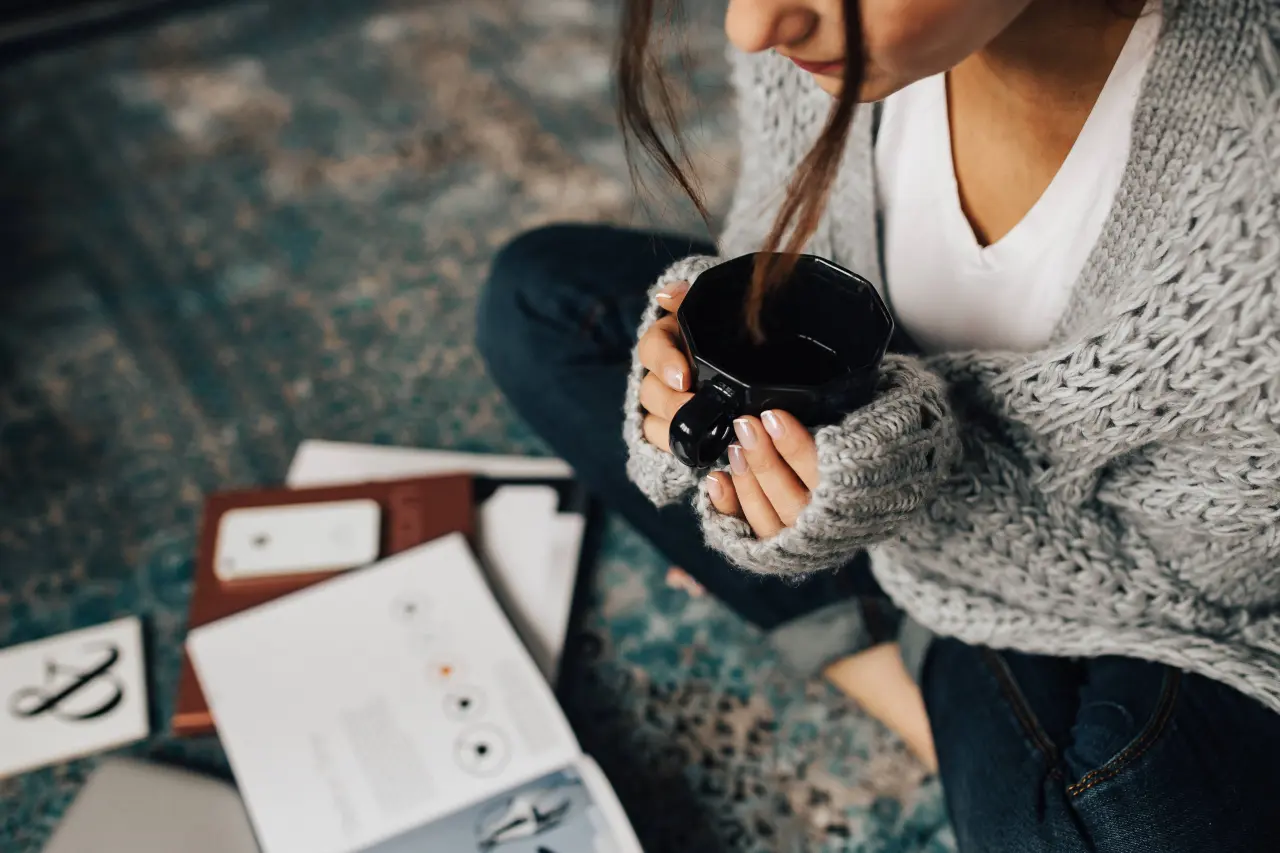 kaboompics_Woman reading magazines on the floor while enjoying hercup of tea Jak neusnout na vavřínech
