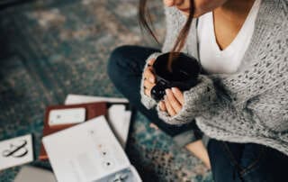 kaboompics Woman reading magazines on the floor while enjoying hercup of tea