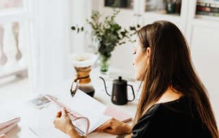 kaboompics The woman drinks coffee and works at her desk
