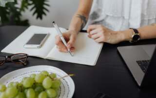 kaboompics a businesswoman writes in a notebook 13869