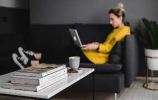 kaboompics young woman sitting on the sofa and working on her laptop 4909